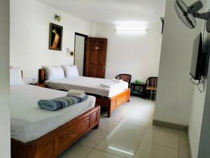 Un dormitorio con dos camas y un televisor. en Khải Lộc Minh Hotel Hồ Chí Minh, en Ho Chi Minh 3 fotos más