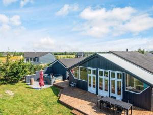 a blue house with a deck and a backyard at 10 person holiday home in Brovst-By Traum in Brovst