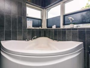 a bath tub in a bathroom with two windows at 10 person holiday home in Brovst-By Traum in Brovst +123 photos