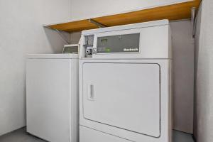 a white refrigerator with a microwave on top of it at Rodeway Inn Carlsbad Caverns Area in Carlsbad