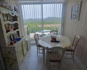 una sala da pranzo con tavolo e sedie e un balcone di Detached house with 3 pools a Cogolin