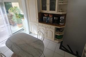 una cucina con tavolo e bancone con macchinetta del caffè di Detached house with 3 pools a Cogolin