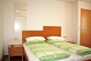 a bedroom with a large bed with green and white blankets at Haus Zisser in Sankt Jakob im Walde