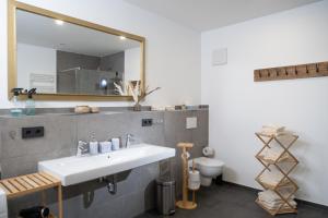 a bathroom with a sink and a mirror at Sauna Oase - stay play relax in Tacherting