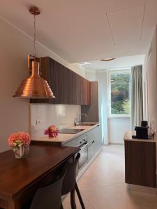 a kitchen with a wooden table and aendant light at Lake Como Aparthotel Cernobbio in Cernobbio