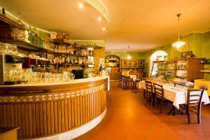 a restaurant with a bar with tables and chairs at Albergo Il Sicomoro in Fivizzano