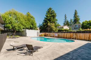 a swimming pool with two chairs and a fence at Blueground Old Mountain View pool nr Park SFO-1876 in San Francisco