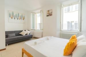 - une chambre blanche avec un lit et un canapé dans l'établissement 2 bedroom apartment on the lake, à Côme