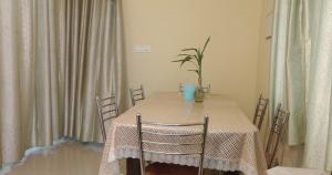 a dining room table with chairs and a vase on it at Skylark Homestay Panchalimedu in Pīrmed