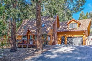 Cette maison en rondins dispose d'une véranda et d'arbres. dans l'établissement Acorn Lodge, à Idyllwild