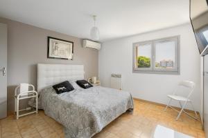 a bedroom with a bed and two chairs and a window at L'Oasis Occitane - Piscine Privée in Le Grau-dʼAgde