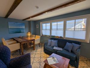 a living room with a blue couch and a table at Dat smucke Reethus - EG in Born