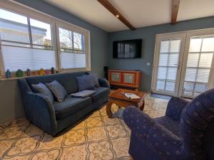 a living room with a blue couch and two chairs at Dat smucke Reethus - EG in Born +1 photo