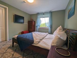 a bedroom with a bed and a television and a window at Dat smucke Reethus - EG in Born