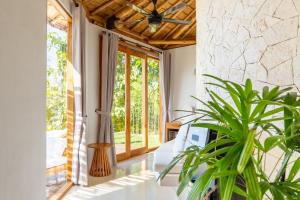 ペニダ島にあるMimpi Villas - Private Luxury & Romantic Villa with seaviewのリビングルーム(天井ファン、植物付)