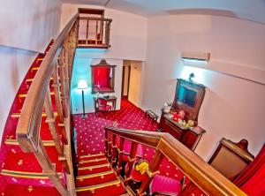 a living room with a staircase and a television at Emire Boutique in Zărneşti