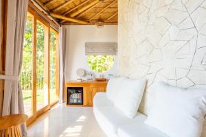 ペニダ島にあるMimpi Villas - Private Luxury & Romantic Villa with seaviewの白いソファと石の壁のあるリビングルーム