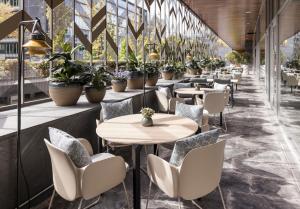a restaurant with tables and chairs and potted plants at Ilunion Atrium in Madrid