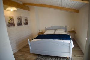 ein Schlafzimmer mit einem weißen Bett in einem Zimmer in der Unterkunft La Galidolle, au calme à 5 minutes de la plage in La Guérinière