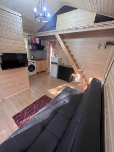 un salon avec un canapé et un escalier dans l'établissement Eco Cottages Borjomi, à Bordjomi