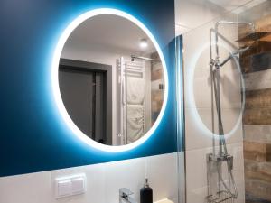 a bathroom with a round mirror and a shower at Comfortable apartment near the river, Dziwnów in Dziwnów