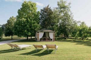 a group of chairs and a gazebo in a park at B&B Ca' degli Orsi in Eraclea