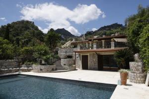 a house with a swimming pool in front of a house at Villa Ragona Taormina in Taormina