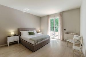 a bedroom with a bed and a window and a chair at Villa Marta by Quokka 360 - 15 minutes from the centre of Como in San Fermo della Battaglia