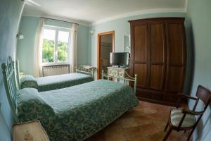 菲維札諾的住宿－Albergo Il Sicomoro，一间卧室设有两张床、一台电视和一扇窗户。