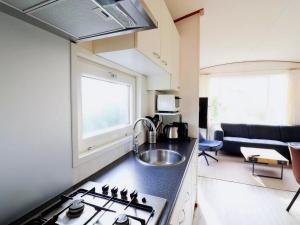 a kitchen with a sink and a stove in a room at Inviting Dune Chalet in Hollum near Golf Course in Hollum
