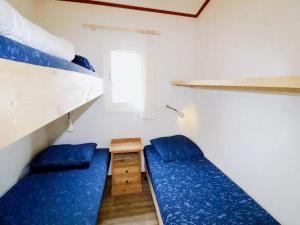 a small room with two beds and a window at Inviting Dune Chalet in Hollum near Golf Course in Hollum +86 photos