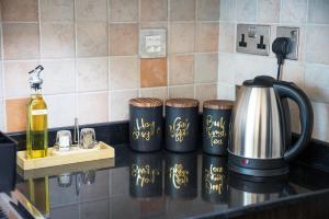 a counter top with four coffee grinders and a kettle at Stylish Luxury Apartment in Al Reem with Pool & Gym in Abu Dhabi +23 photos