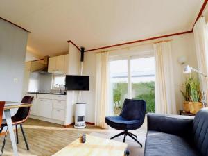 a living room with a couch and chairs and a table at Inviting Dune Chalet in Hollum near Golf Course in Hollum
