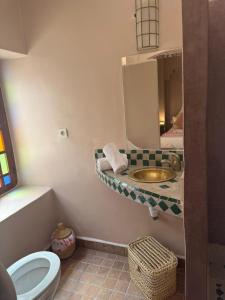 a bathroom with a sink and a toilet and a mirror at Riad DIHYA & Rooftop Pool in Marrakesh +115 photos