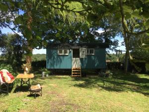 a tiny house in a yard with a table at The Scrumpy Shepherd, Brandeston in Cretingham