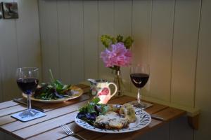 a table with two plates of food and two glasses of wine at The Scrumpy Shepherd, Brandeston in Blundeston