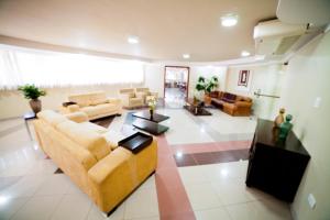 ein großes Wohnzimmer mit Sofas und Tischen in der Unterkunft Copas Executive Hotel in Cascavel