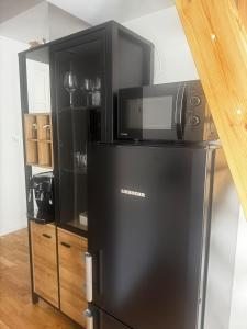 un micro-ondes posé sur un réfrigérateur dans l'établissement Apartament SUNNY Przy Rynku z klimatyzacją i parkingiem, à Kielce
