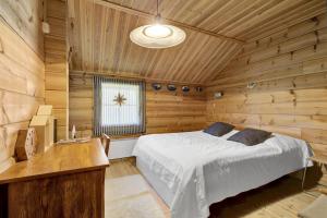 une chambre avec un lit dans une cabane en bois dans l'établissement Villa Christina, à Pyhätunturi