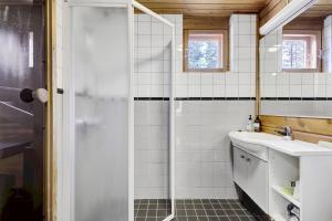une salle de bain avec douche et lavabo dans l'établissement Villa Christina, à Pyhätunturi 32 autres photos