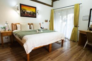 a bedroom with a bed and a desk and a window at Europa Bed and Breakfast in Beacon Bay