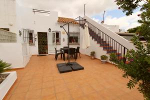 a patio with a table and chairs and stairs at Casita con piscina comunitaria in La Nucía