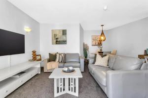 グレネルグにあるGlenelg Outlook - Beachfront Stay by Moseley Squareのソファとテレビのあるリビングルーム +12枚の写真