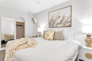 グレネルグにあるGlenelg Outlook - Beachfront Stay by Moseley Squareの白いベッドルーム(枕付きの大きな白いベッド付)