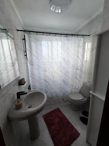 a white bathroom with a sink and a toilet at Casa da Vila in Vila Franca do Campo +5 photos