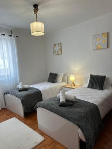 a bedroom with two beds and a pendant light at Casa da Vila in Vila Franca do Campo