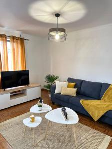 a living room with a blue couch and two tables at Casa da Vila in Vila Franca do Campo