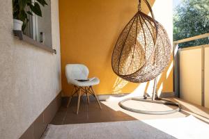 una sedia bianca appoggiata su un portico accanto a un muro di Apartament Kraków & Cracow Apartment 70m2 a Skorka