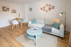 un soggiorno con un divano e un tavolo di Sailor's Cabin - Neues und zentrales Apartment von STAY YOUR WAY a Bremerhaven