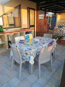 a table with chairs and a table cloth on a patio at Appartamento Cristalli di Sale in San Vito lo Capo